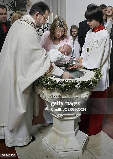 Germany: Priest Josef Kaiser christens little Julian Lorenz Benedikt Reissl hold by his godparent Silvia Flachner during a ceremony on Easter Sunday...