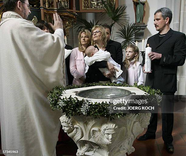 Germany: Priest Josef Kaiser christens little Julian Lorenz Benedikt Reissl as the boy's parents Annette and Lorenz Reissl and godparent Silvia...