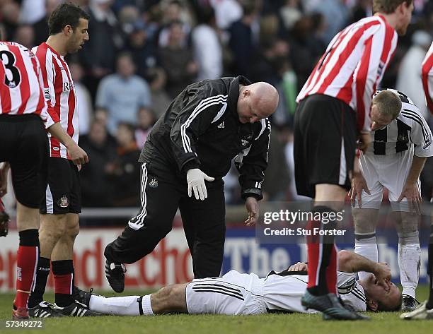 Newcastle captain Alan Shearer recieves treatment from physio Dereck Wright after a bad tackle to his left knee during the Barclays Premiership match...