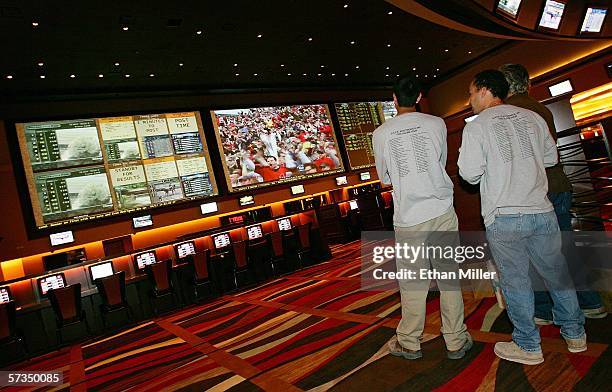 Workers watch the end of a baseball game at the race and sports book at the Red Rock Casino April 17, 2006 in Las Vegas, Nevada. The 96-foot long...