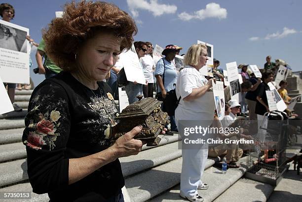 Kimberly Hebert of Meraux holds an urn containing the remains of five of her dogs who died in Hurricane Katrina during a rally to support Senate Bill...