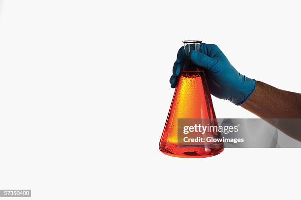 close-up of a beaker in a person's hand - glass beaker stock pictures, royalty-free photos & images