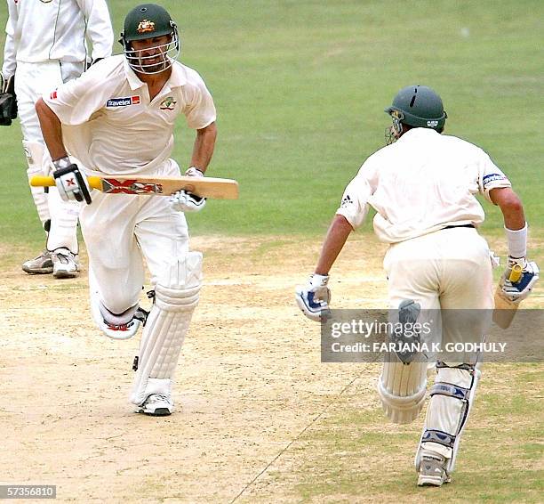 Chittagong, BANGLADESH: Australian batsmans Jason Gillespie and Micheal Hussey run between wickets during the the third day of the second Test match...