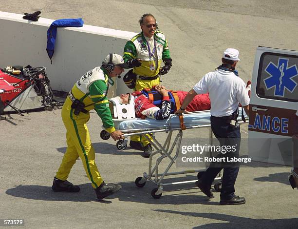 Mauricio Gugelmin is carefully extracated from his car by the CART Simple Green safety crew after an accident during practice for the Firestone...