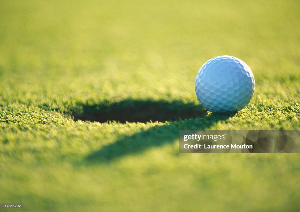 Golf ball at edge of hole, close-up