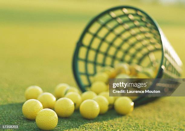 spilled basket of yellow golf balls, close-up - drivingrange stockfoto's en -beelden