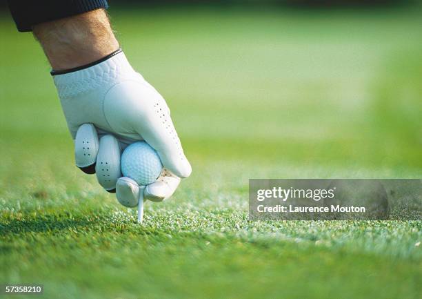 golfer's gloved hand teeing up, close-up - tee sports equipment fotografías e imágenes de stock