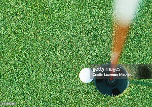 golf ball at edge of hole, view from directly above - green golf course stockfoto's en -beelden
