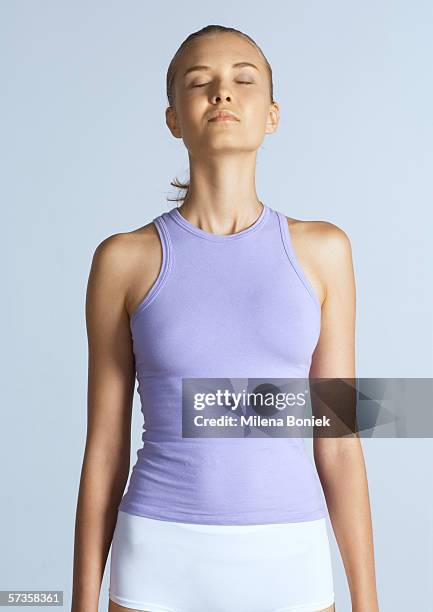 woman standing with arms by sides and eyes closed - unterhemd stock-fotos und bilder