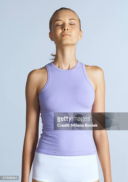 woman standing with arms by sides and eyes closed - good posture 個照片及圖片檔