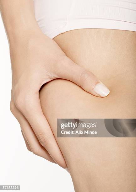 woman squeezing thigh, close-up - hamstring stock pictures, royalty-free photos & images