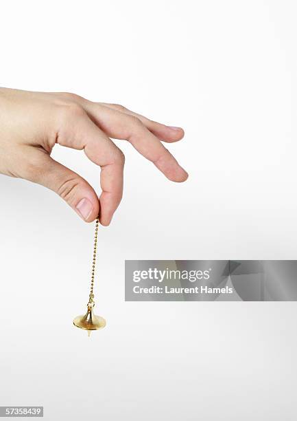 hand holding pendulum - pendel stock-fotos und bilder