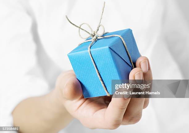 hand holding out small package - small parcel stock pictures, royalty-free photos & images