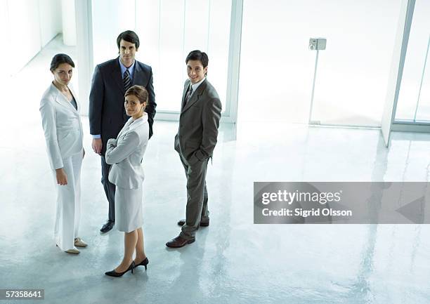 four executives standing in office building lobby - ビジネスフォーマル ストックフォトと画像