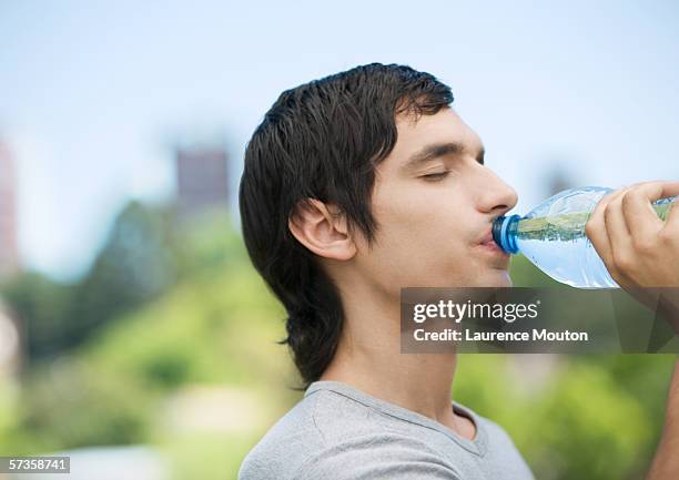 young man drinking water from bottle - mullet hairstyle stock pictures, royalty-free photos & images