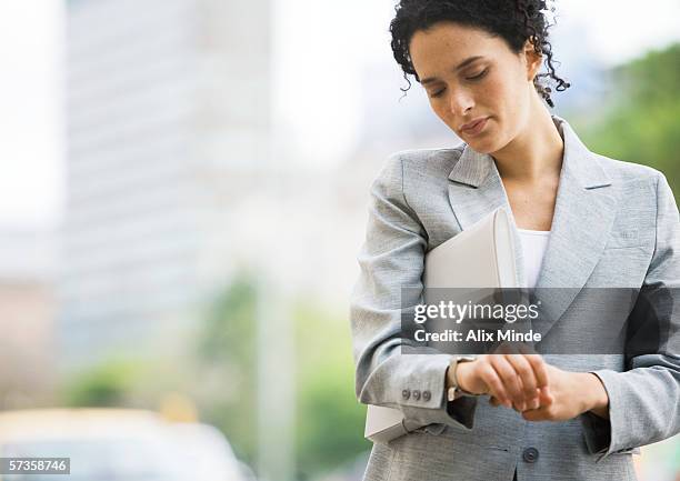 businesswoman checking watch - departure board front on fotografías e imágenes de stock