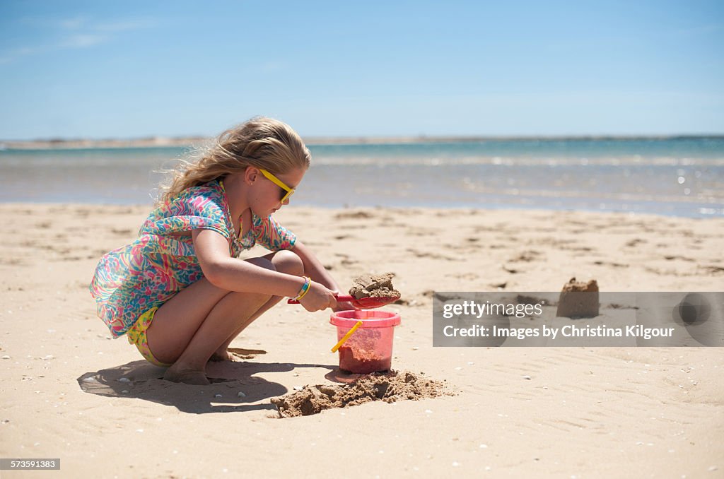 Young girl building sandcastles