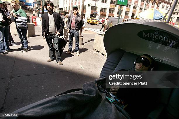 Man takes a post tax filing rest in a sleeping pod set up by a popular anti-perspirant for last minute tax filers in front of the Farley Post office...