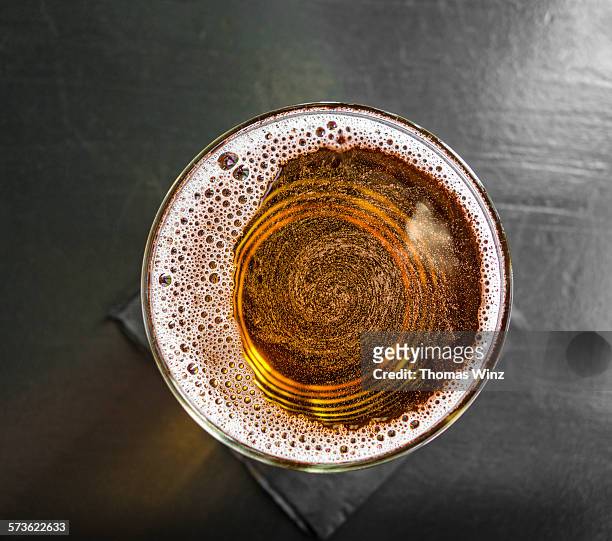 swirl in a pint of cider - alcohol top view stock-fotos und bilder