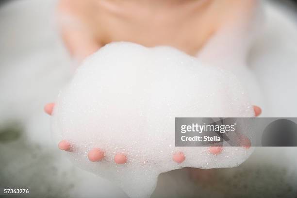 woman with arms outstretched and holding bubbles - schaumbad stock-fotos und bilder