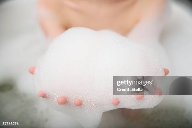 woman with arms outstretched and holding bubbles - bubblebath stock pictures, royalty-free photos & images