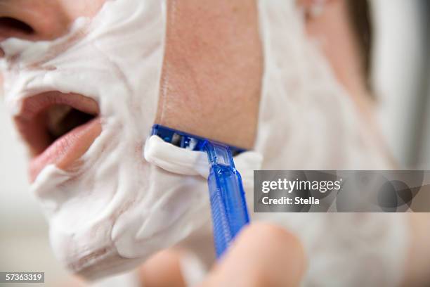 side view of man shaving - man shaving face stock-fotos und bilder