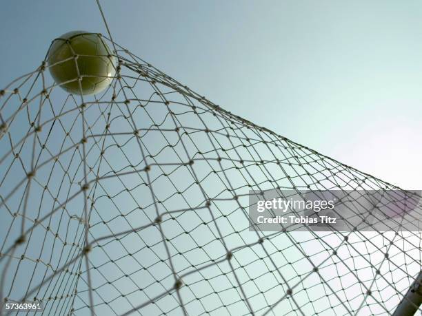 a soccer ball in a goal - cage de but de football photos et images de collection