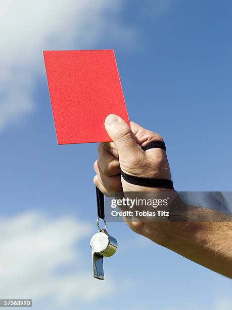 a soccer referee holding up a red card - arbitre photos et images de collection