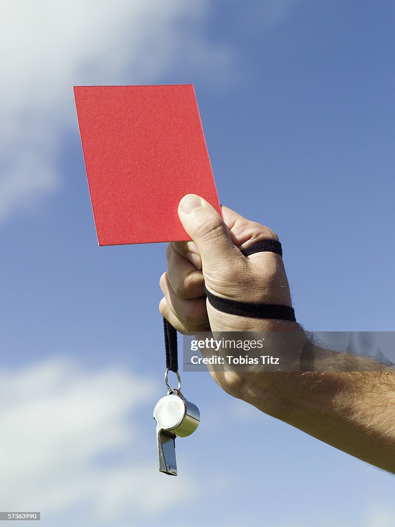 A soccer referee holding up a red card