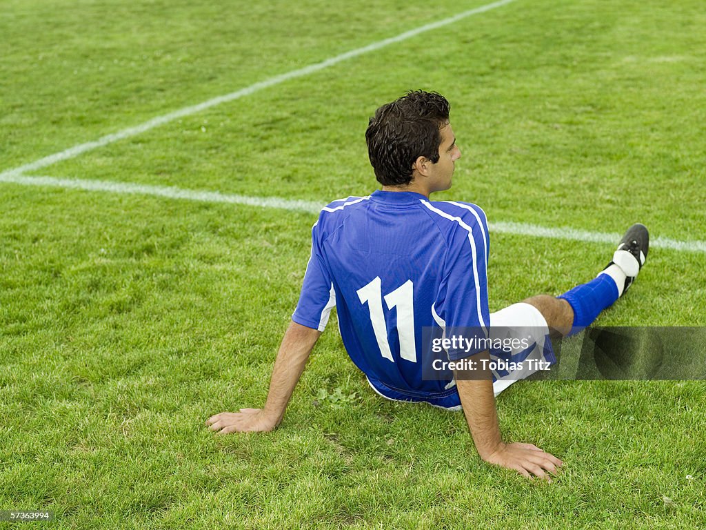 A soccer player resting on the sidelines
