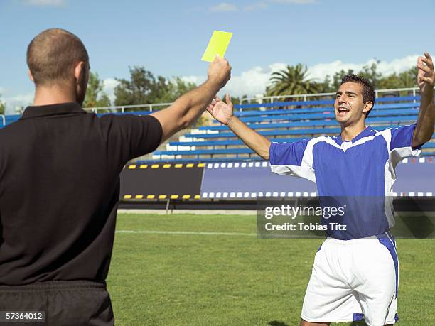 a referee giving a soccer player a yellow card - bad goalkeeper stock pictures, royalty-free photos & images