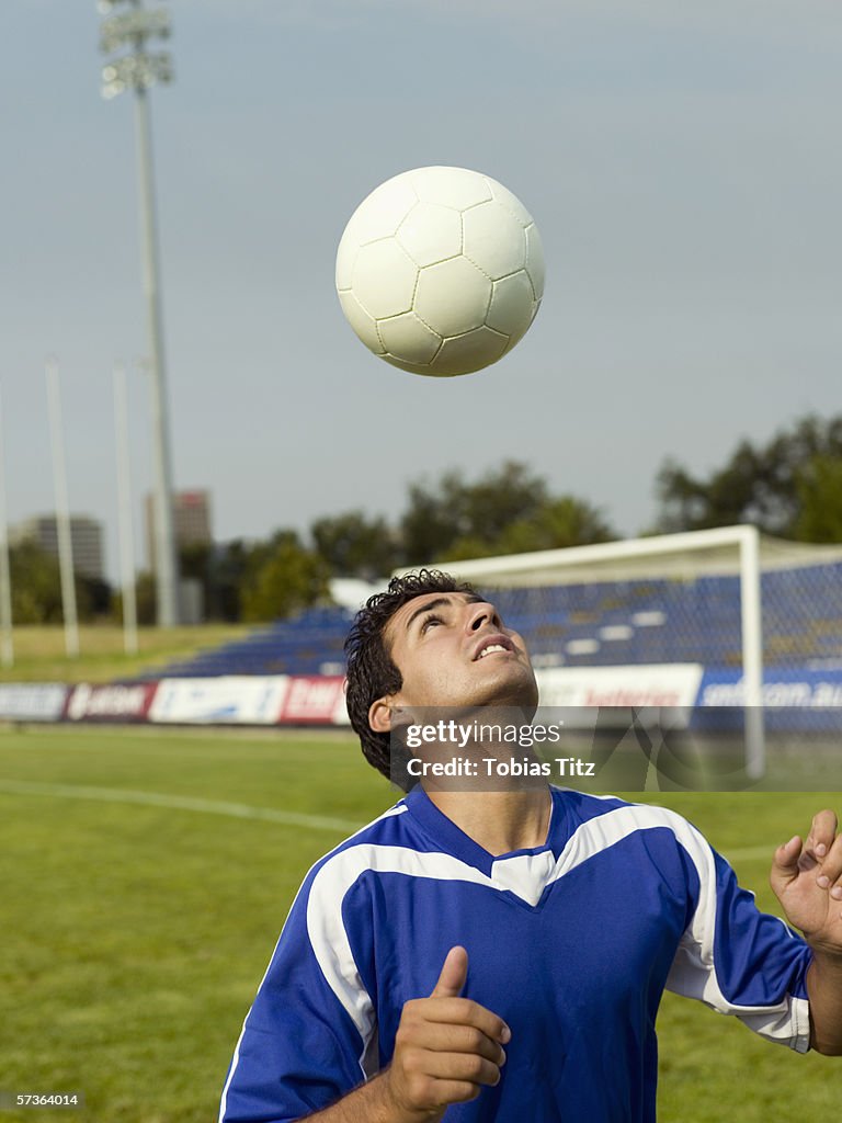 A soccer player hitting a ball with his head