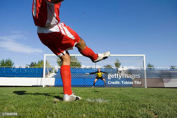 a soccer player taking a penalty shot - strafstoß oder strafwurf stock-fotos und bilder