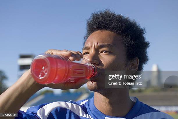 a soccer player drinking a sports drink - sports drinks stock pictures, royalty-free photos & images