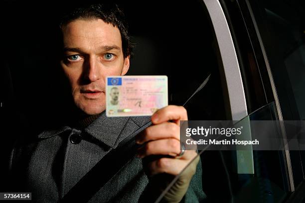 male driver holding his id card - id card stockfoto's en -beelden