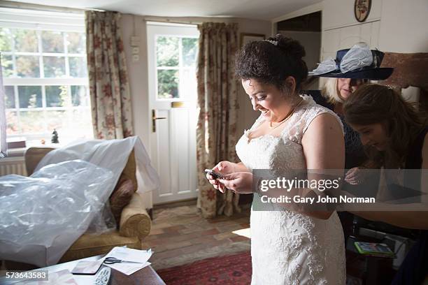 bride's mum and sister helping to dress bride. - europe bride stock-fotos und bilder