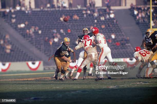 American football player Len Dawson , quarterback for the Kansas City Chiefs, throws the ball as opponant Lee Roy Coffey closes in during the first...