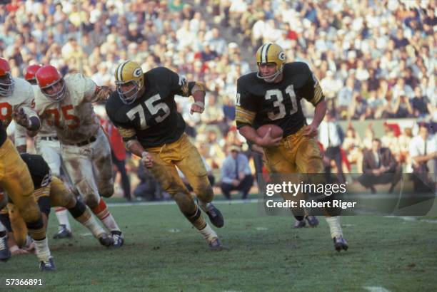 American football player Jim Taylor of the Green Bay Packers runs with the ball as teammate Forrest Gregg blocks for him during the first AFL-NFL...