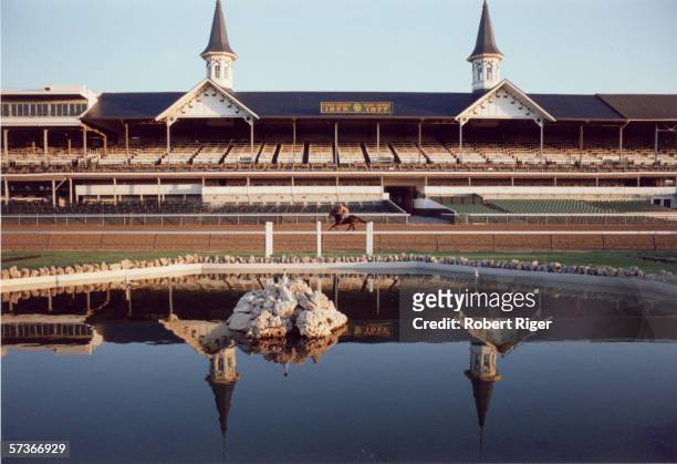 View of the grandstand at the Churchill Downs race track as a jockey works out a horse prior to the Kentucky Derby, Louisville, Kentucky, 1978.