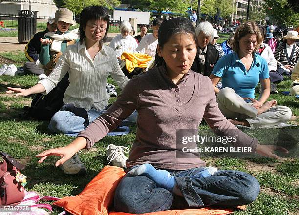 Washington, UNITED STATES: Falun Gong practitioners meditate 19 April, 2006 in McPherson Square park in Washington, DC. Ahead of the official visit...