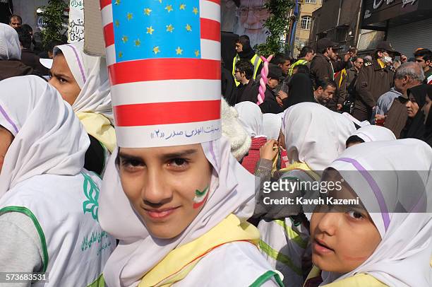 School girl wears a card board hood with U.S. Flag printed on it while marching on Revolution street on the day of the 35th anniversary of the...