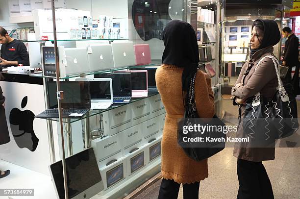 Two veiled women stand outside an Apple store selling MacBook Pro and iMac along with iPhones and tablets in Paytakht mall on 23rd February 2012 in...