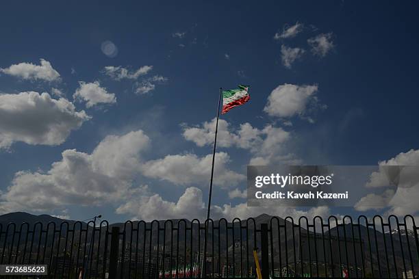 An Iranian flag seen amass against the cloudy blue sky on April 22, 2013 in Tehran, Iran.