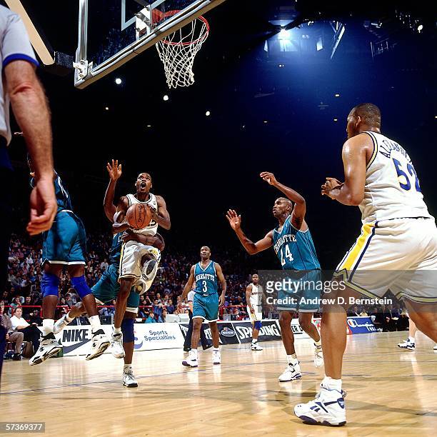 Latrell Sprewell of the Golden State Warriors attempts a shot against Larry Johnson of the Charlotte Hornets during a 1994 Exhibition Game played at...
