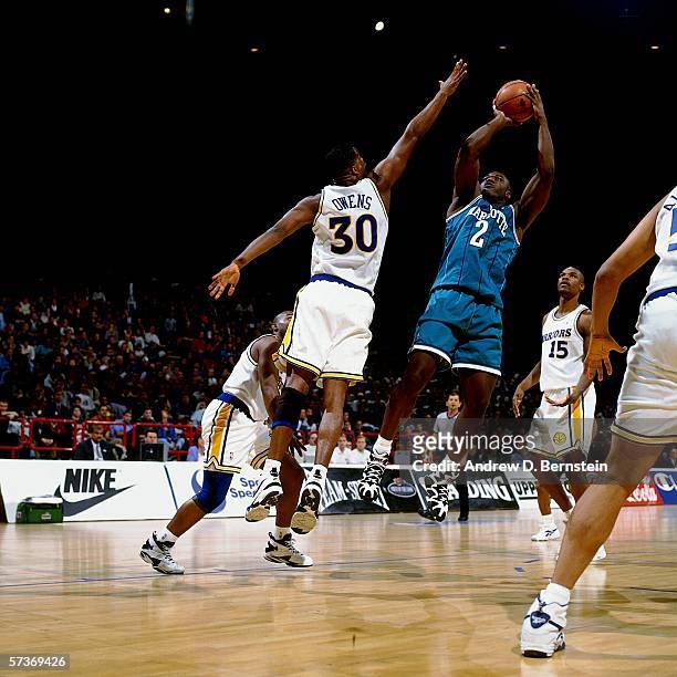 Larry Johnson of the Charlotte Hornets shoots a jump shot against Billy Owens of the Golden State Warriors during a 1994 Exhibition Game played at...