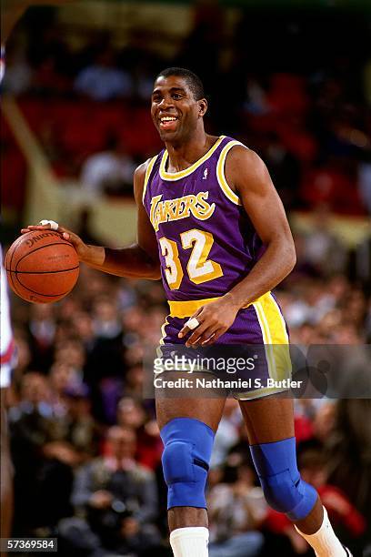 Magic Johnson of the Los Angeles Lakers moves the ball up court during a game against the New York Knicks circa 1990 at Madison Square Garden in New...