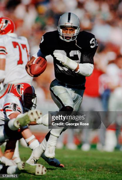 Los Angeles Raiders running back Marcus Allen dodges a tackle as he runs with the ball during a 1986 NFL game against the Atlanta Falcons at the Los...