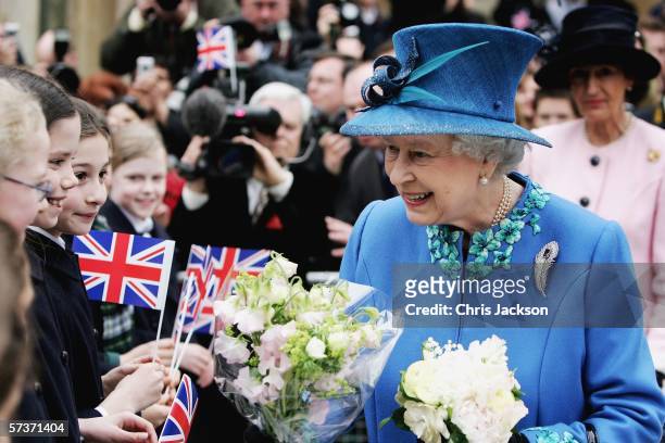 Queen Elizabeth II meets school children as she leaves BBC Broadcasting House to mark the anniversary of the granting of the Corporation's Royal...