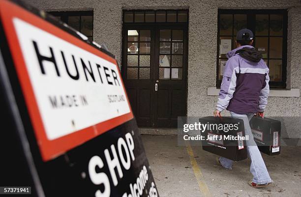 Woman is seen with pair of Hunter wellington boots at the factory shop on April 20, 2006 in Dumfries in Scotland. The iconic Wellington boot company...