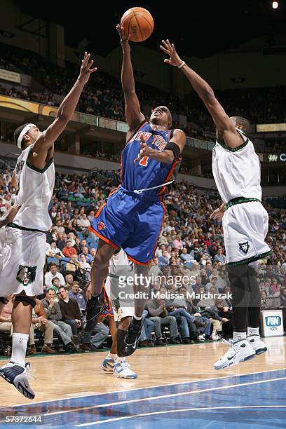 Steve Francis of the New York Knicks puts up a shot against Eddie Griffin and Rashad McCants of the Minnesota Timberwolves during the game at Target...